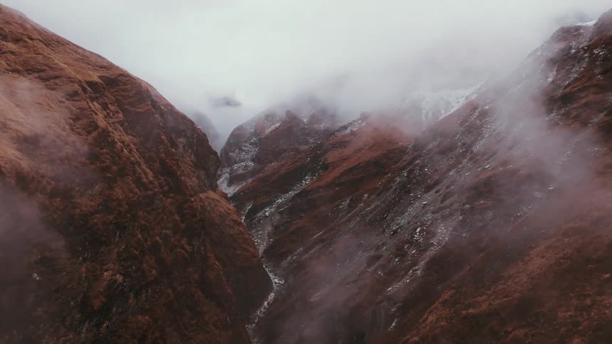 Aerial panorama of a mountain valley in brown coloring with fog