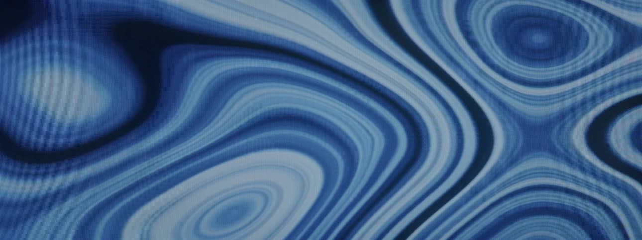 Different shades of blue liquid pool and move around each other merging at times and separating at others