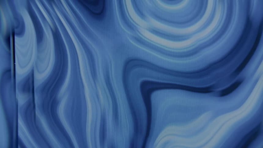 A puddle of white and blue paint is swirling around creating unique shapes