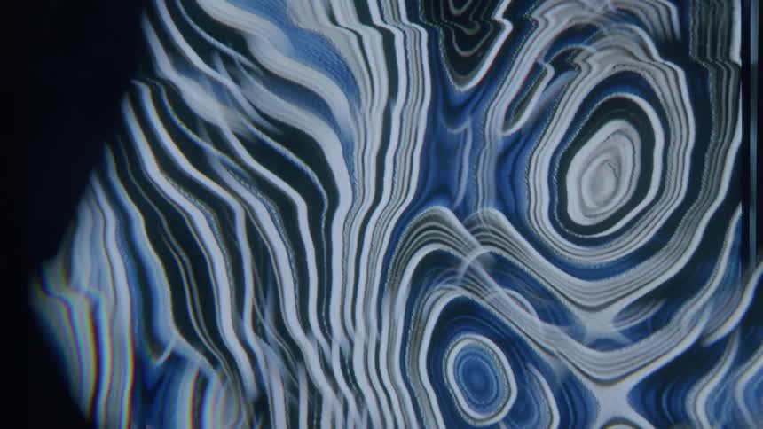A puddle of blue and white paint is swirling around creating unique shapes