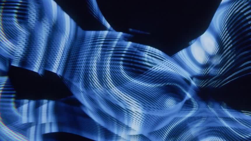 Abstract projection of moving neon blue lines against a black background