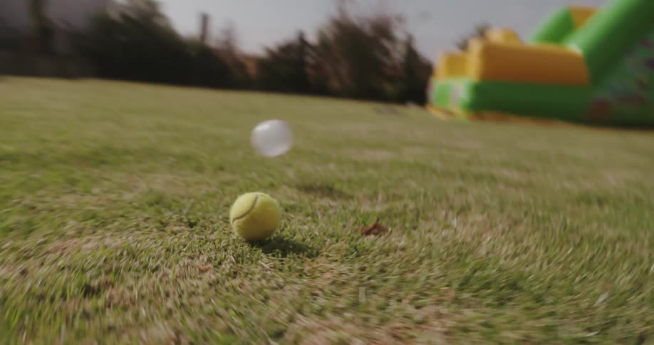 A boy is kicking a ball in the yard