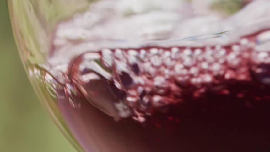 Wine pouring into a glass and sliding back down the sides