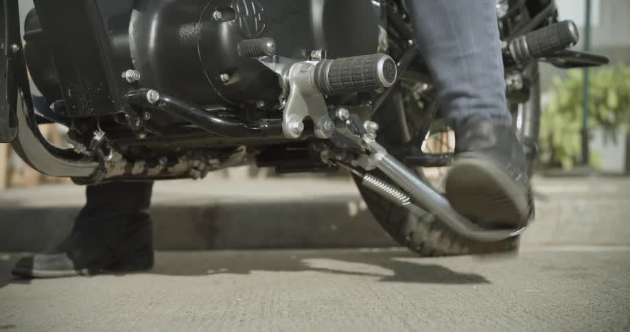 Person putting their kickstand down on their motorcycle