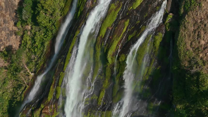 Several large waterfalls flow down the side of a steep mountain