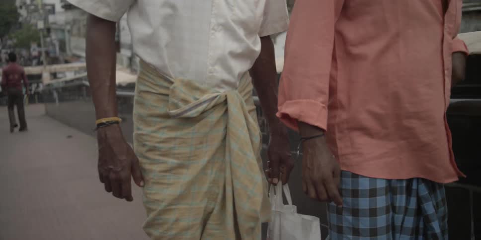 Men walk on a sidewalk outdoors