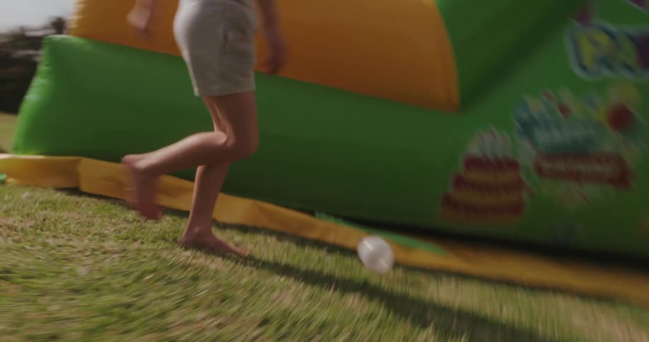 Barefoot child running on the grass with a transparent ball