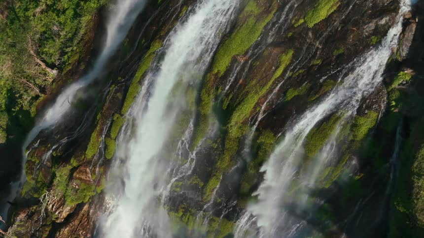 A waterfall pours over the cliff