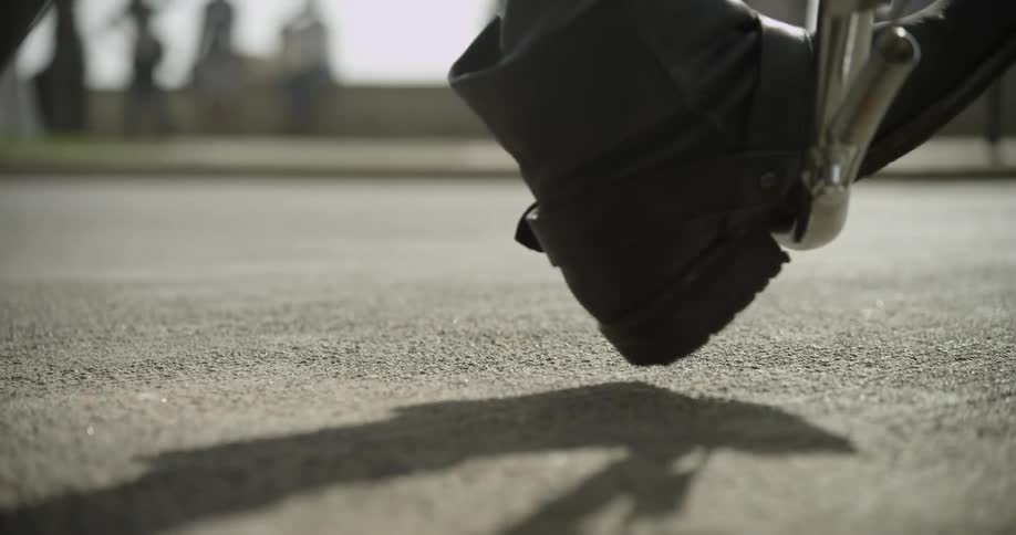 Extreme close-up  of a boot putting a kickstand down on a street