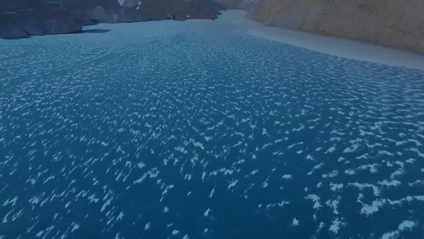 Frozen river in the canyon between snowy mountains