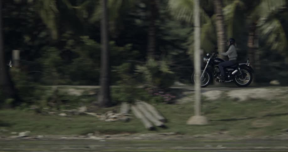Two people ride motorcycles during the day
