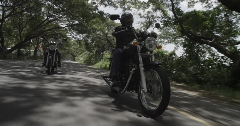 Motorcycles travel down the road on a sunny day