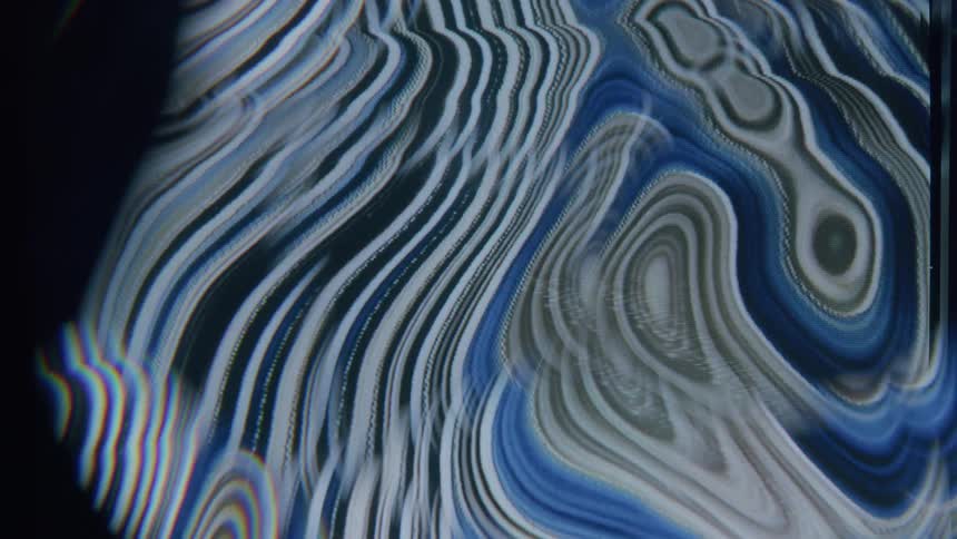 Bands of liquid in multiple shades of blue imploding to create new shapes and bands
