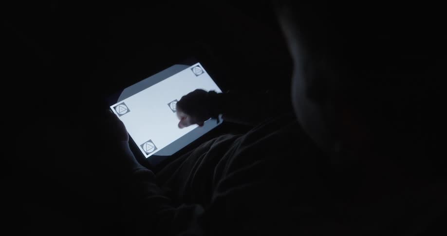 A young boy repeatedly pushes a tablet screen without any results