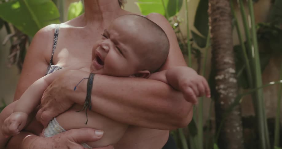 A grandmother holds her grandaughter and she yawns