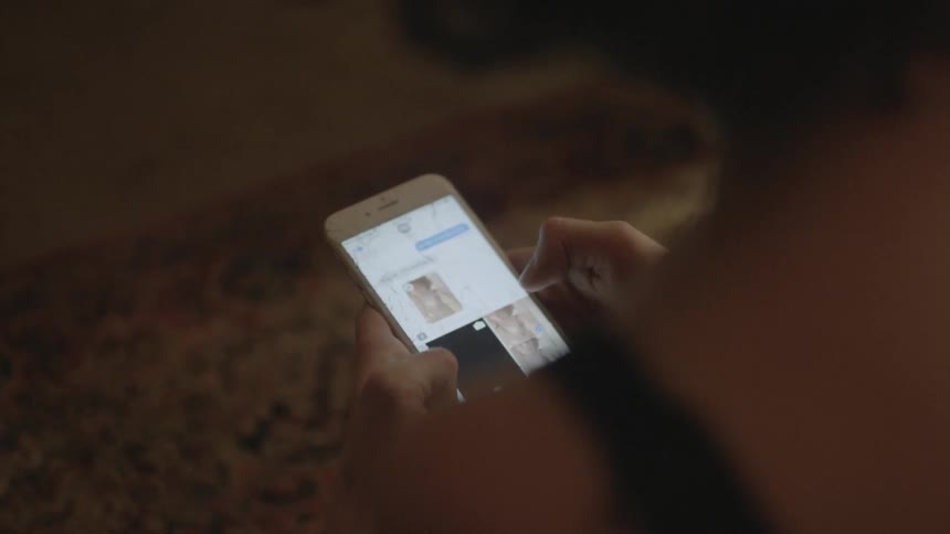 A woman browses pictures on her phone