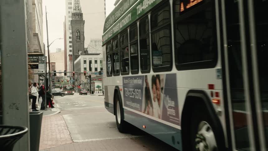 Bus traveling along a city street on a cloudy day