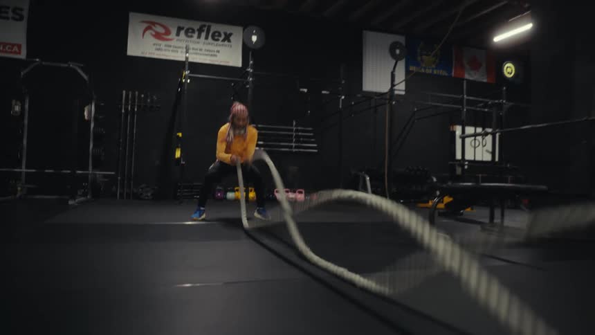 A man swings ropes in the gym