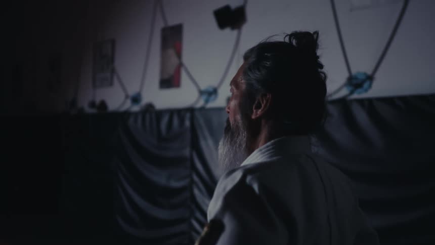 Man with his hands on his waist concentrated and wearing a white kimono costume