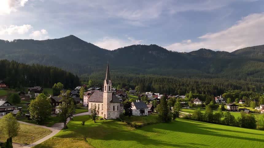 Church surrounded by small homes at the foot of the mountains