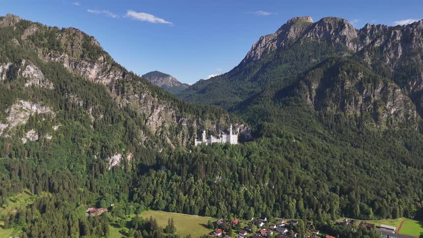 Landscape of a village in a mountain valley and a white castle in the background