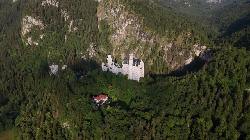 Aerial scene of a castle on top of a mountain with vegetation