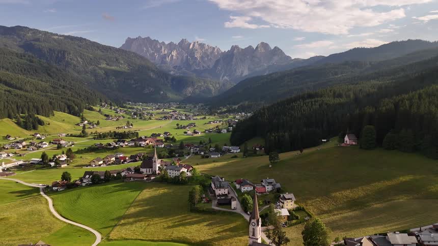 A village is between mountains and forests