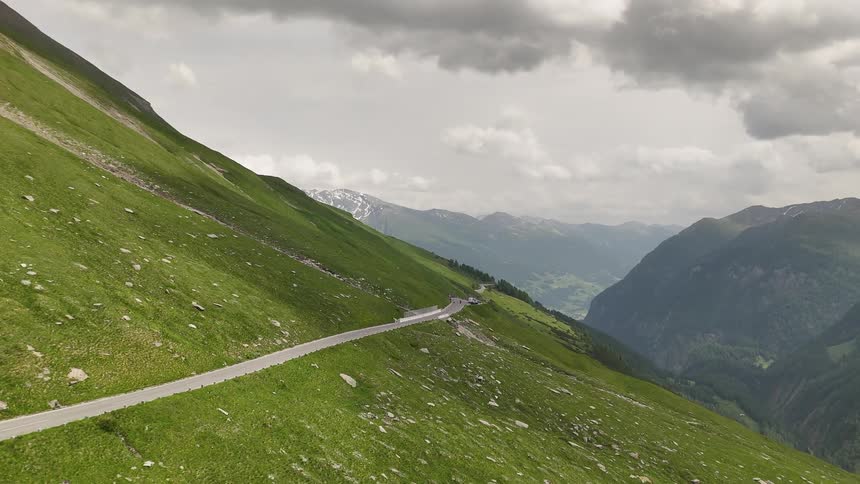Narrow road that winds up a grassy mountainside
