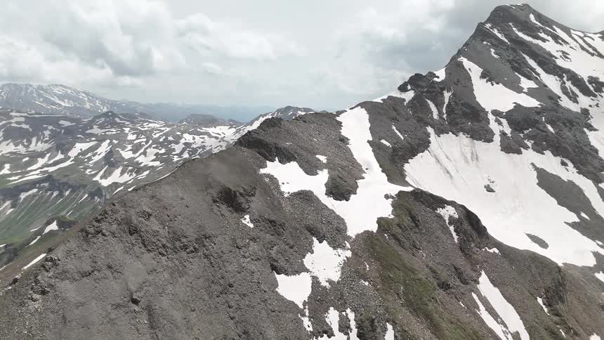 Mountains with sharp peaks covered sparsely in snow