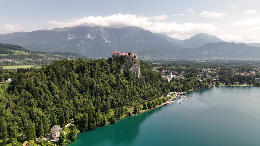Aerial landscape of a lake surrounded by mountains vegetation and a city