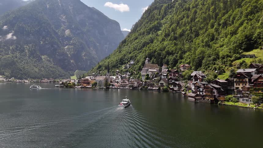 Boats on a lake in front of the forested mountains