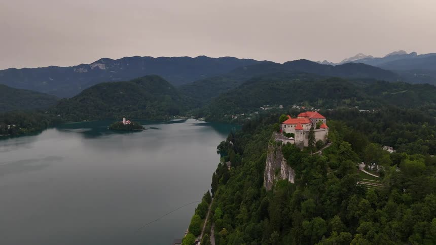 Aerial landscape of a castle on a mountain peak by a lake