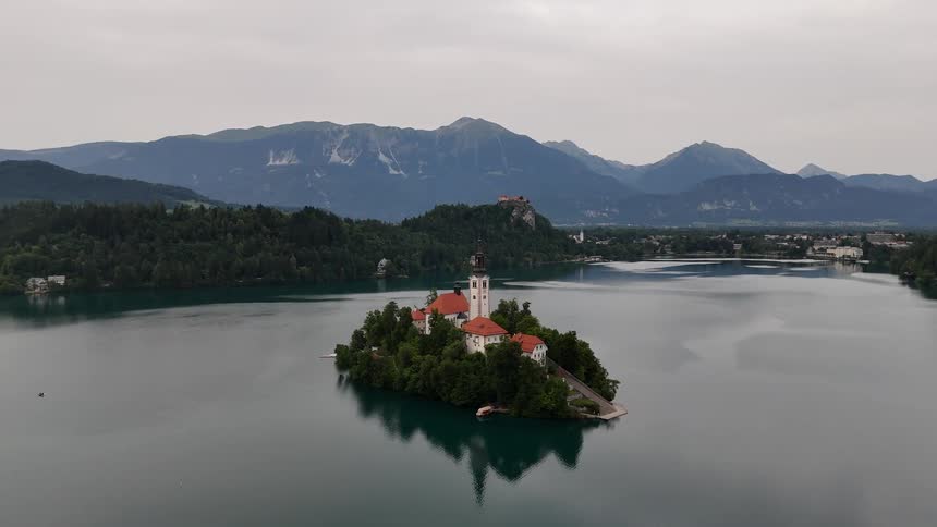 A castle style home sits on a small island in a lake