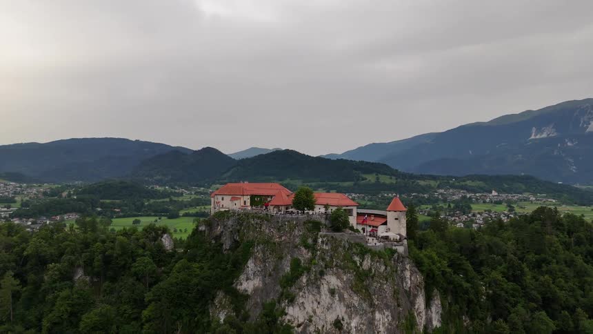 Aerial panorama of a building on a mountain peak with trees around it