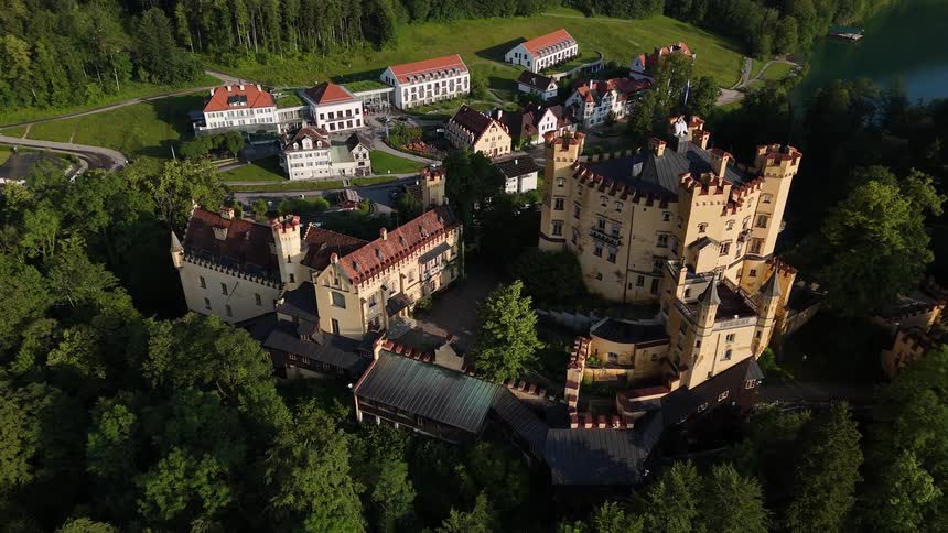 Aerial view of a castle on a hill and in the background a village in a mountainous valley