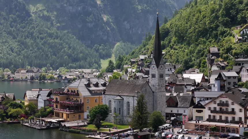 Aerial view of a church in a lakeside village surrounded by mountains