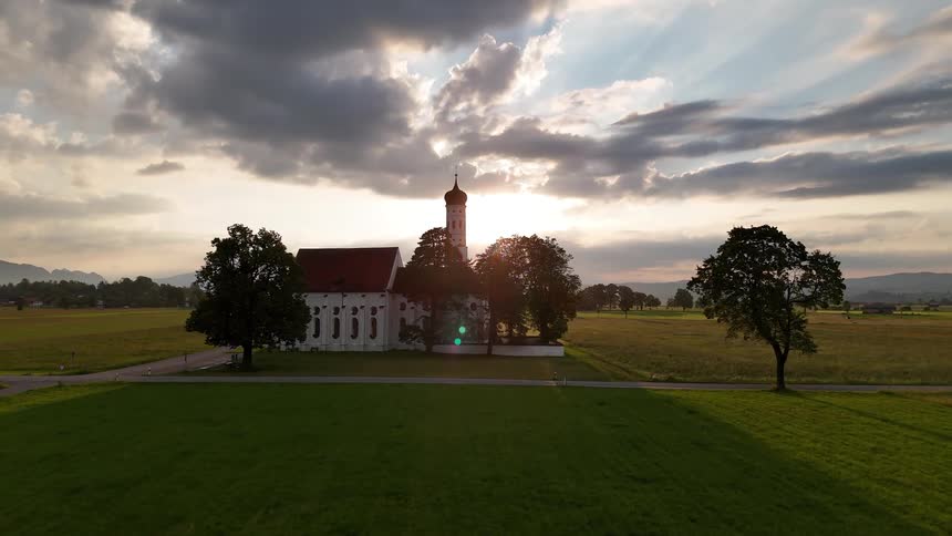 Religious center in a greenish field with sunrise on the horizon