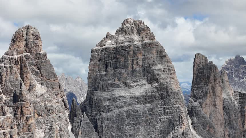 Some tall rock formations in a remote environment with white clouds in the sky