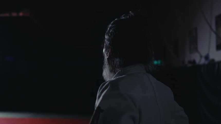 A man stands in a dark room looking around