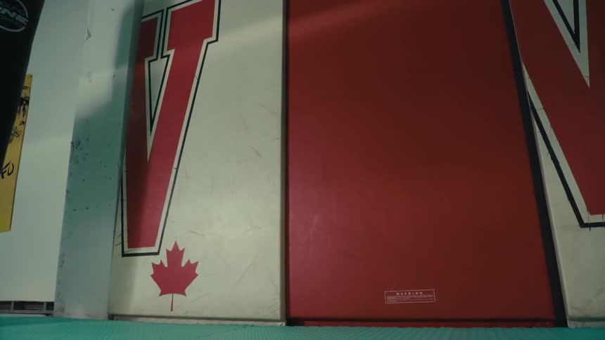 Boxer training with a body bag in the gym casts a shadow on the wall