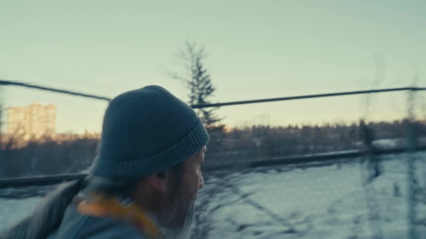 Determined man with a hat on his head running in the snow