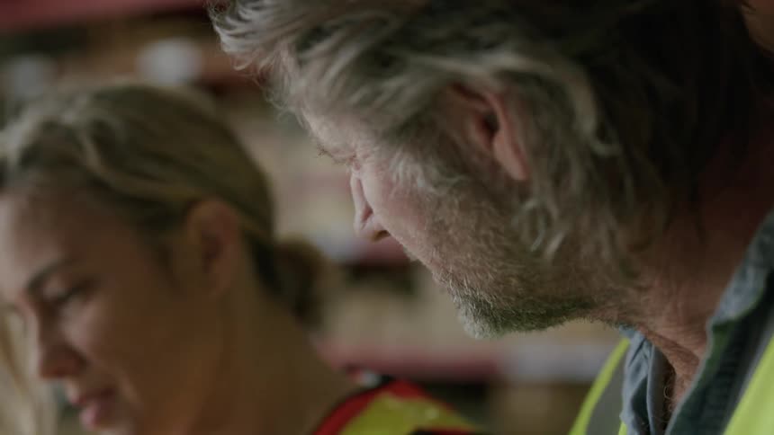 A male and female have a conversation while at work