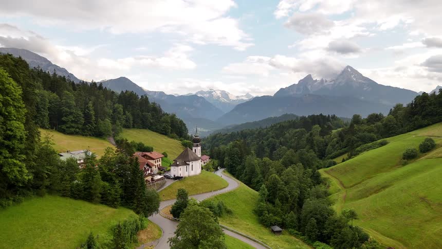 Small village on the hills of a greenish mountain valley with trees