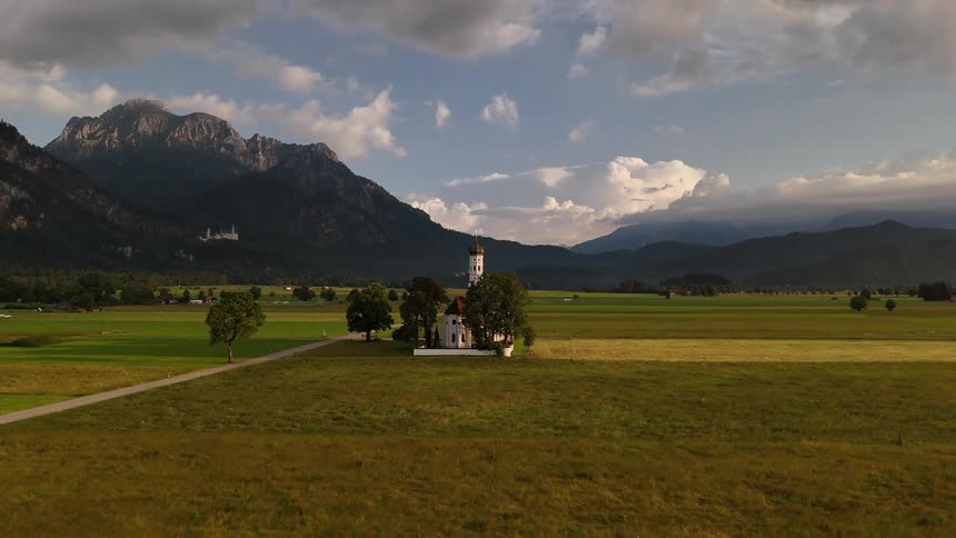 Church in the center of a field with mountains on the horizon