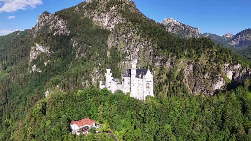 Large castle built at the top of a mountainous valley surrounded by vegetation