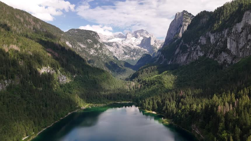 Aerial landscape of a calm lake surrounded by mountains and greenery