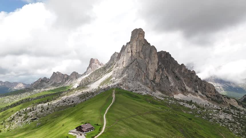 A tall mountain rises from a grassy hill