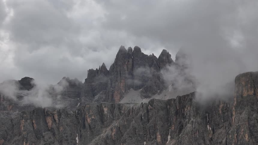 Clouds cover the top of the craggy mountains