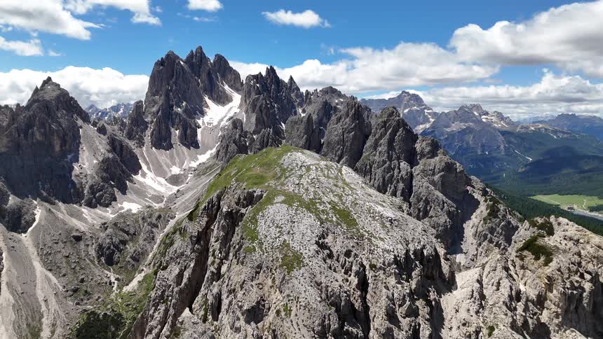 Aerial view of pointed mountains with cliffs in a valley