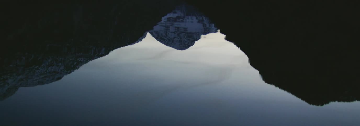 Reflection of the tip of a snowy mountain in a body of water
